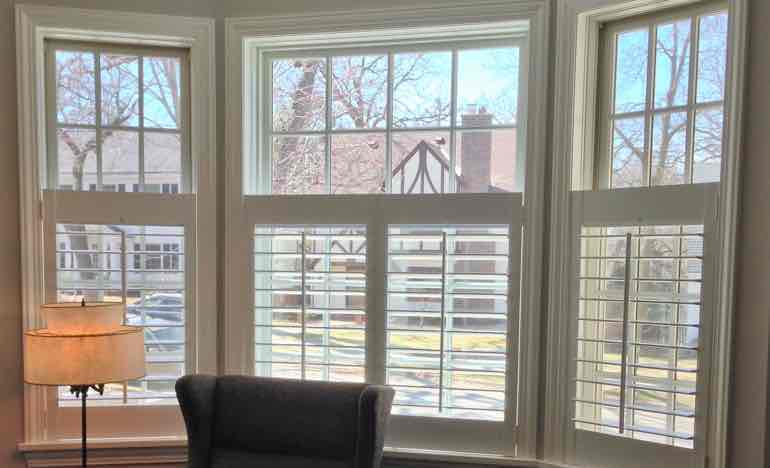 Bottom half insulating shutters in living room bay window.